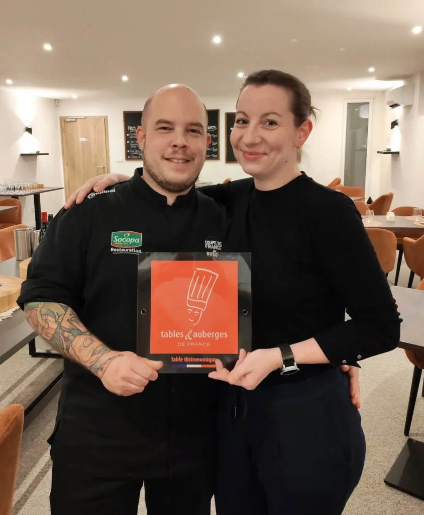 Émilie et le Chef Damien fiers de présenter la plaque du label Tables et Auberges de France pour leur restaurant L'Atelier d'E&D à Weitbruch.